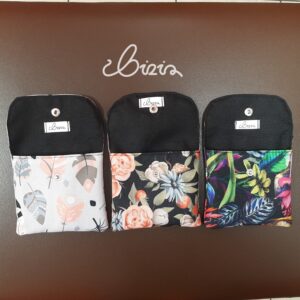 Etui na podpaski i tampony. Wykonane z materiału wodoodpornego. Wzór z piórami, różami i kwiatowy. Etui otwarte