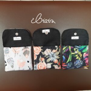 Etui na podpaski i tampony. Wykonane z materiału wodoodpornego. Wzór z piórami, różami i kwiatowy. Etui otwarte