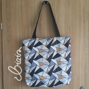 Torba na ramię z dużym uchem. Nosi się ją na ramieniu. Z materiału wodoodpornego w geometryczne wzory.