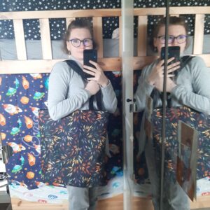 Torba na ramię we wzór jesiennych liści. Pokazane użycie na osobie ludzkiej. Torba na ramię w zastosowaniu użytkowym.