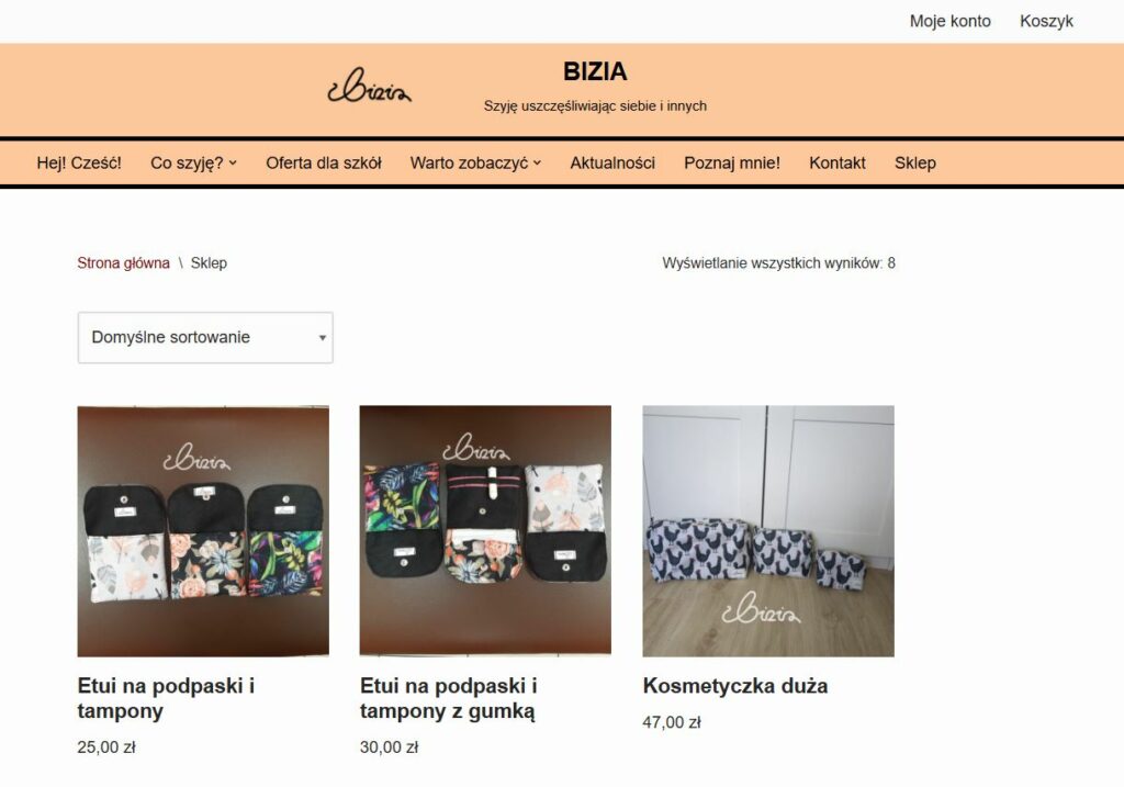 Na zdjęciu znajduje się pierwsza strona sklepu internetowego BIZIA w kolorach brzoskwiniowym i czarnym. Produkty na obrazku to etui na podpaski i tampony oraz kosmetyczka duża